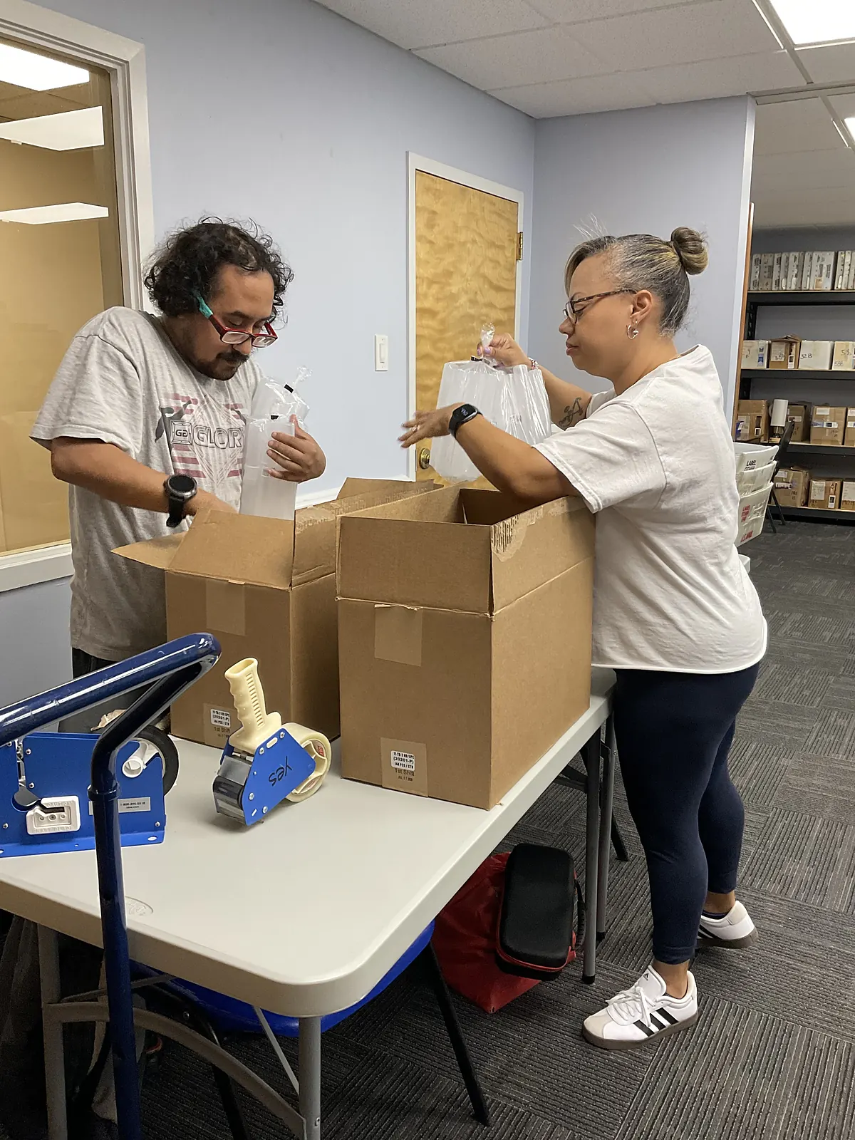 Team members packing items into shipping boxes