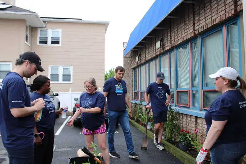 A volunteer team gathers beside the Friendship House garden before beginning work.
