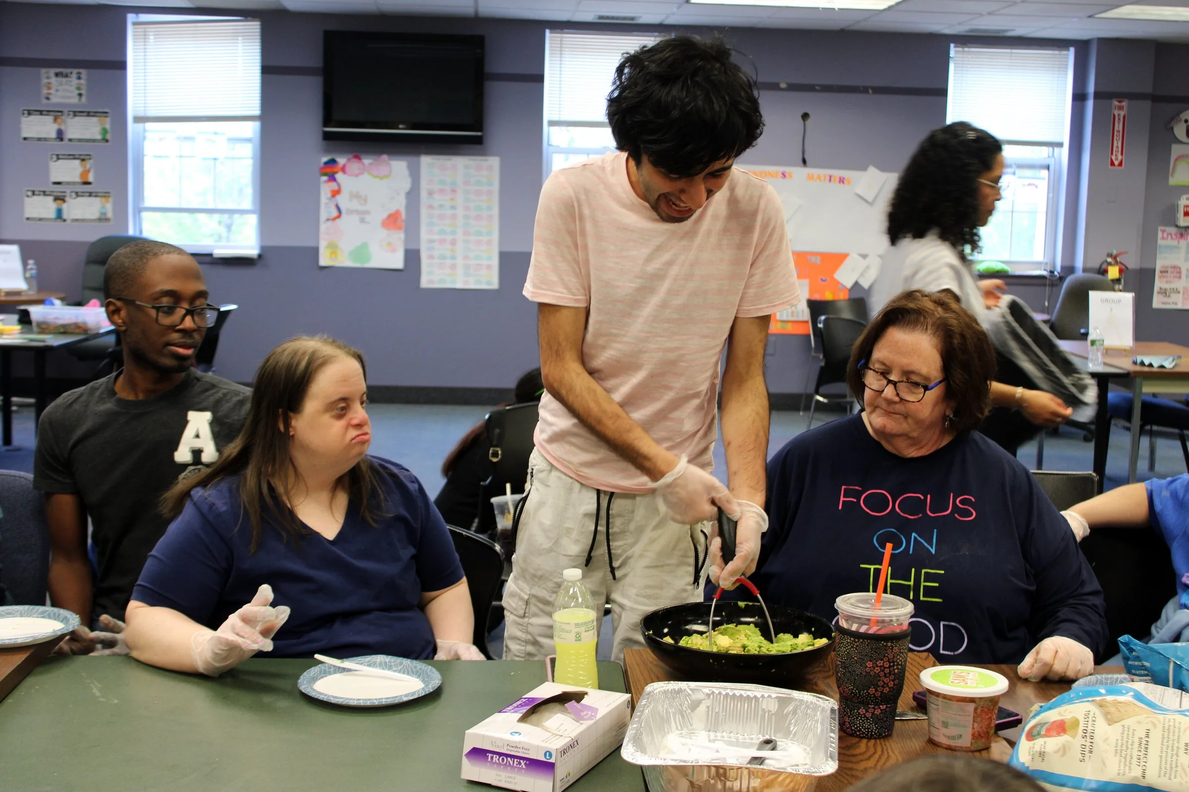 Members and staff preparing food together at a table