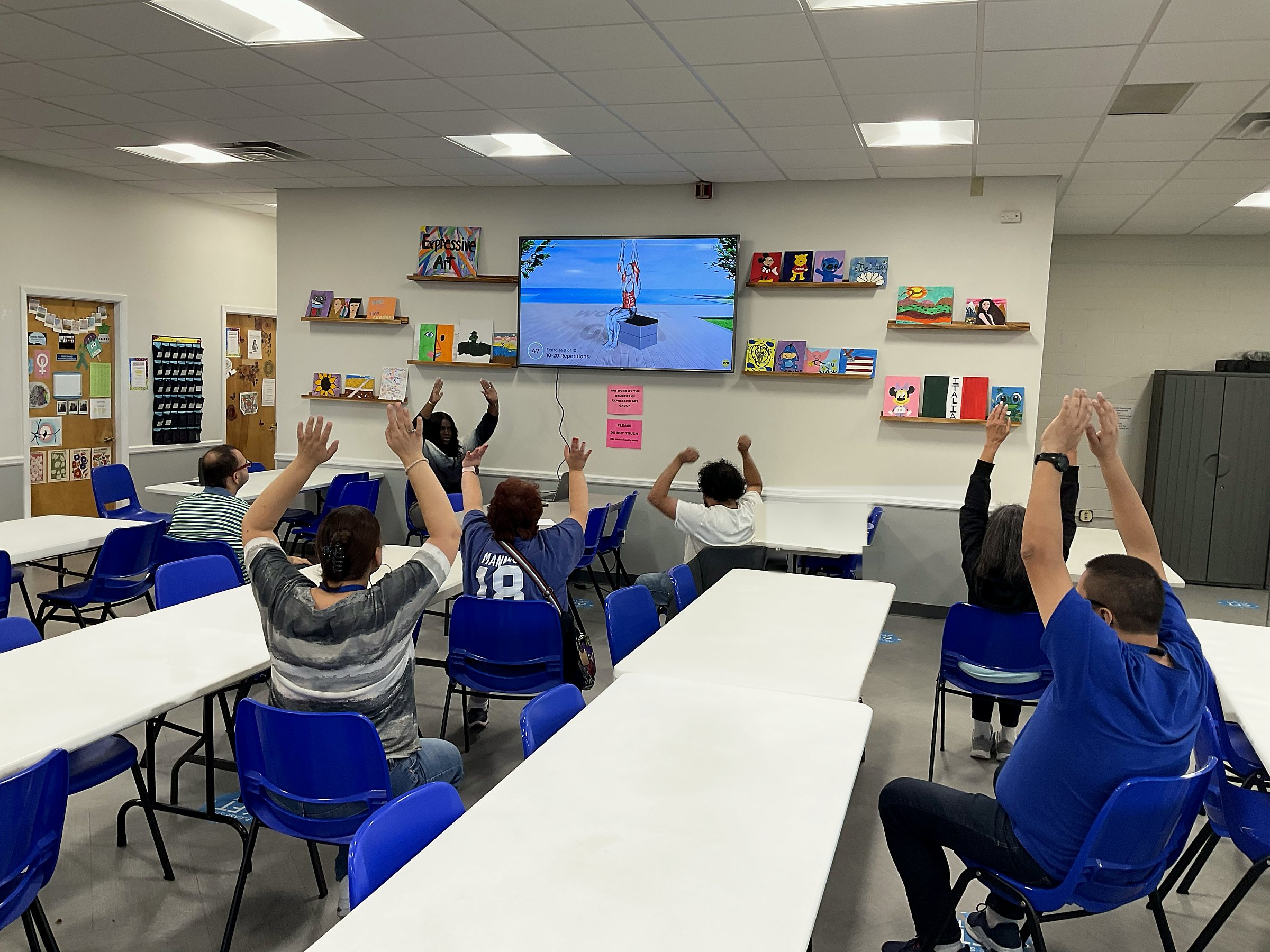 Partial Care members following a seated group exercise video