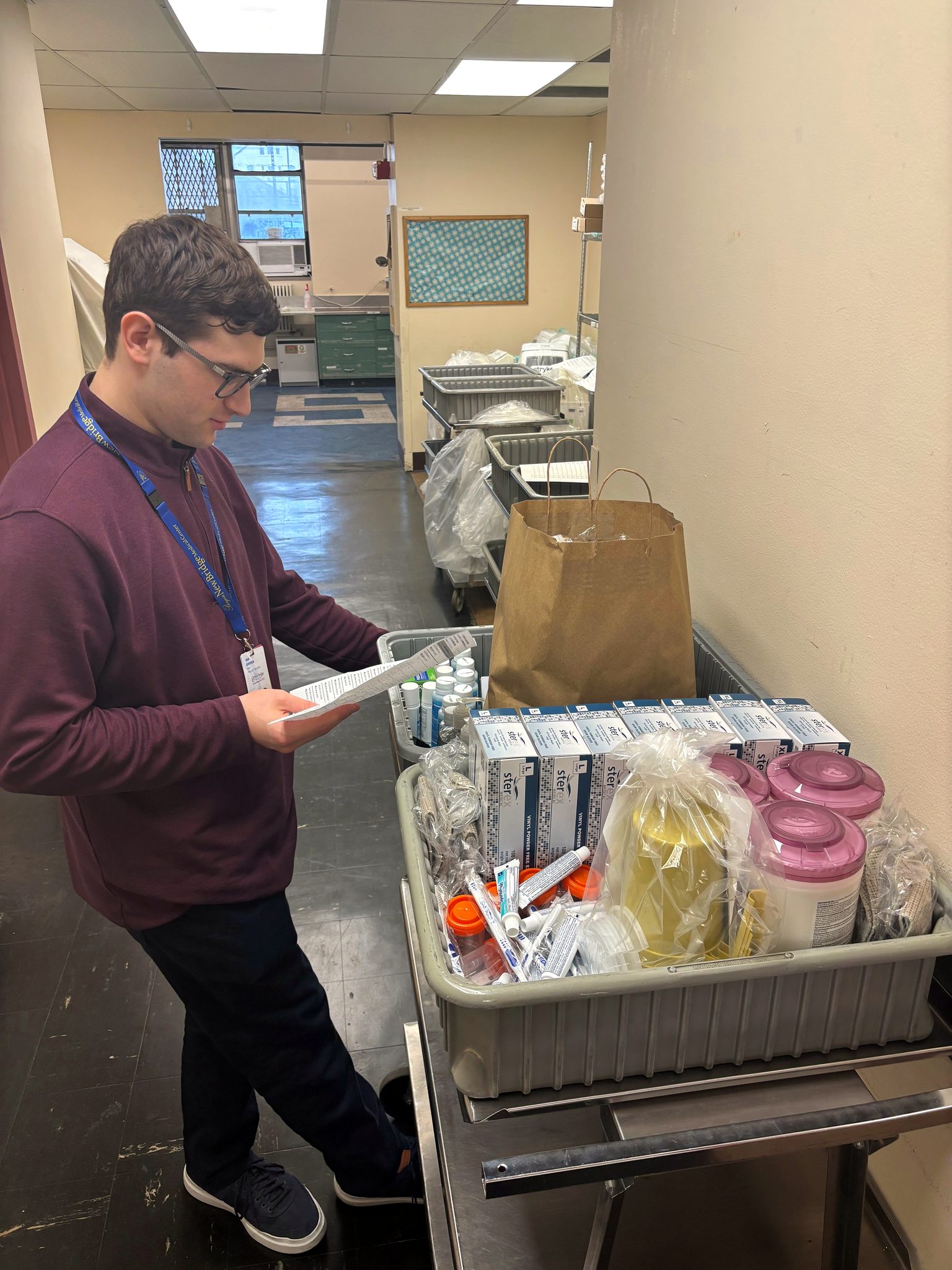 A Project SEARCH intern checking supplies on a cart