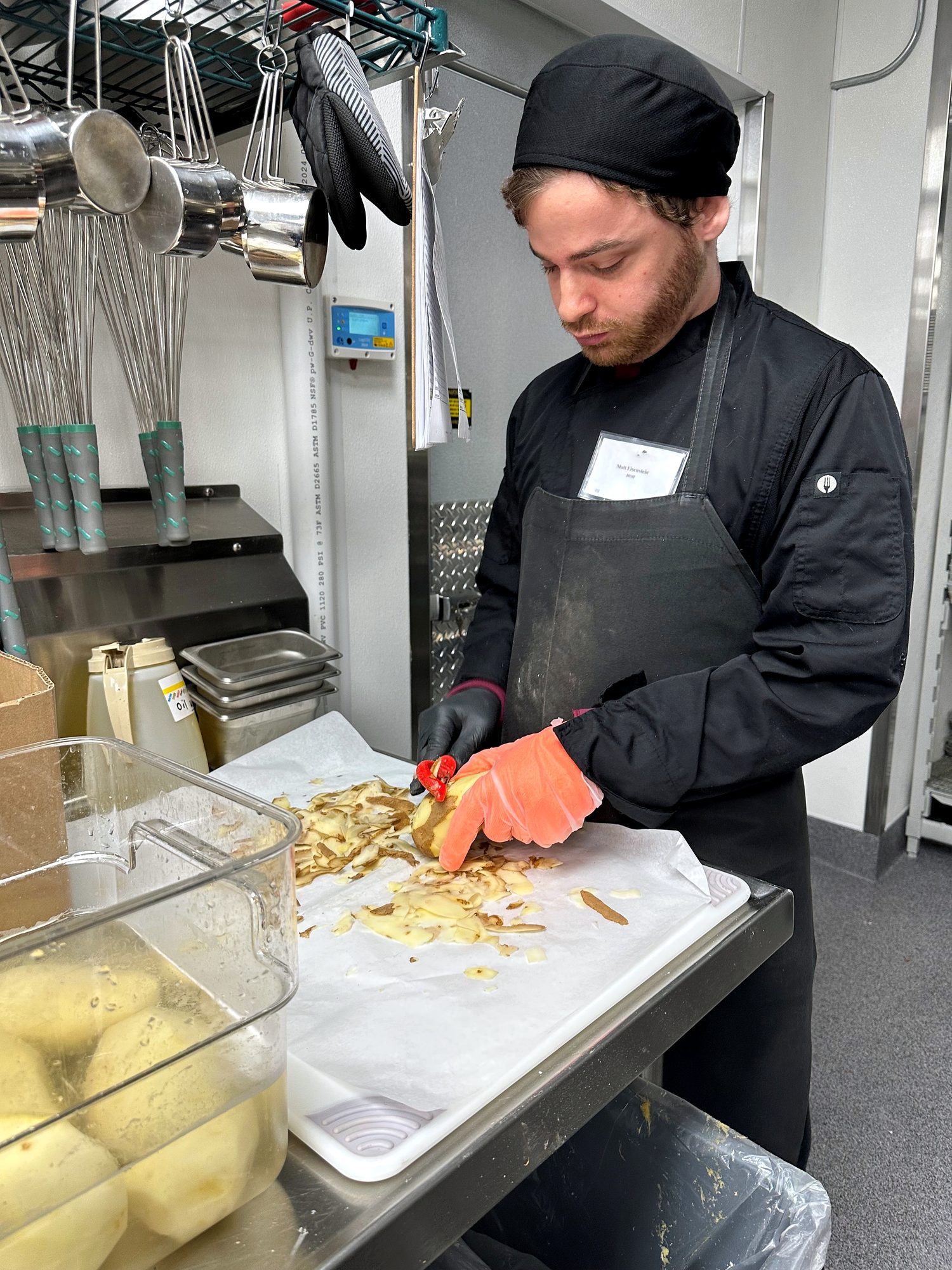 A Supported Employment participant preparing food in a commercial kitchen